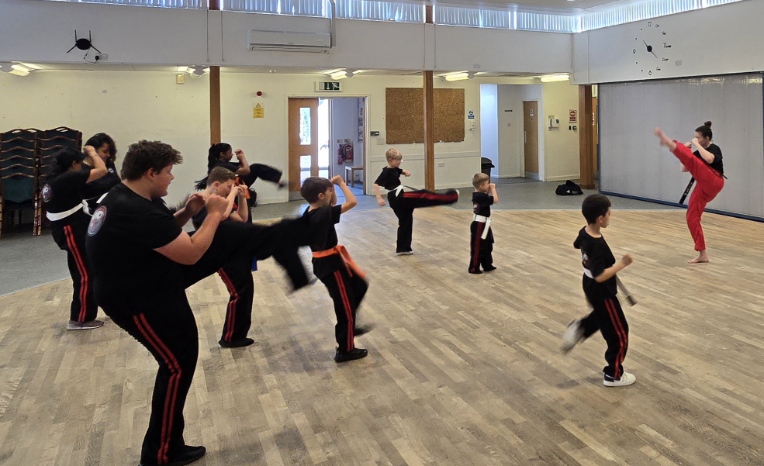 Students practising kicks during Saturday class