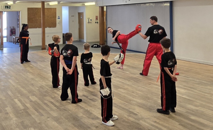 Instructor demonstrating high kick to students